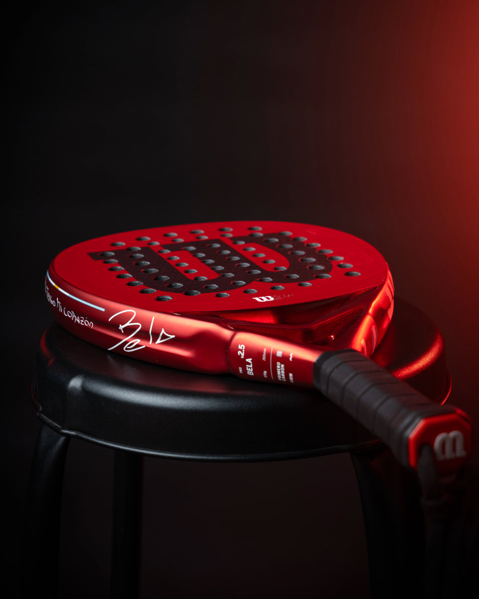 Paleta de padel Wilson Bela Pro V2.5 Edición Limitada Argentina apoyada sobre un banco.